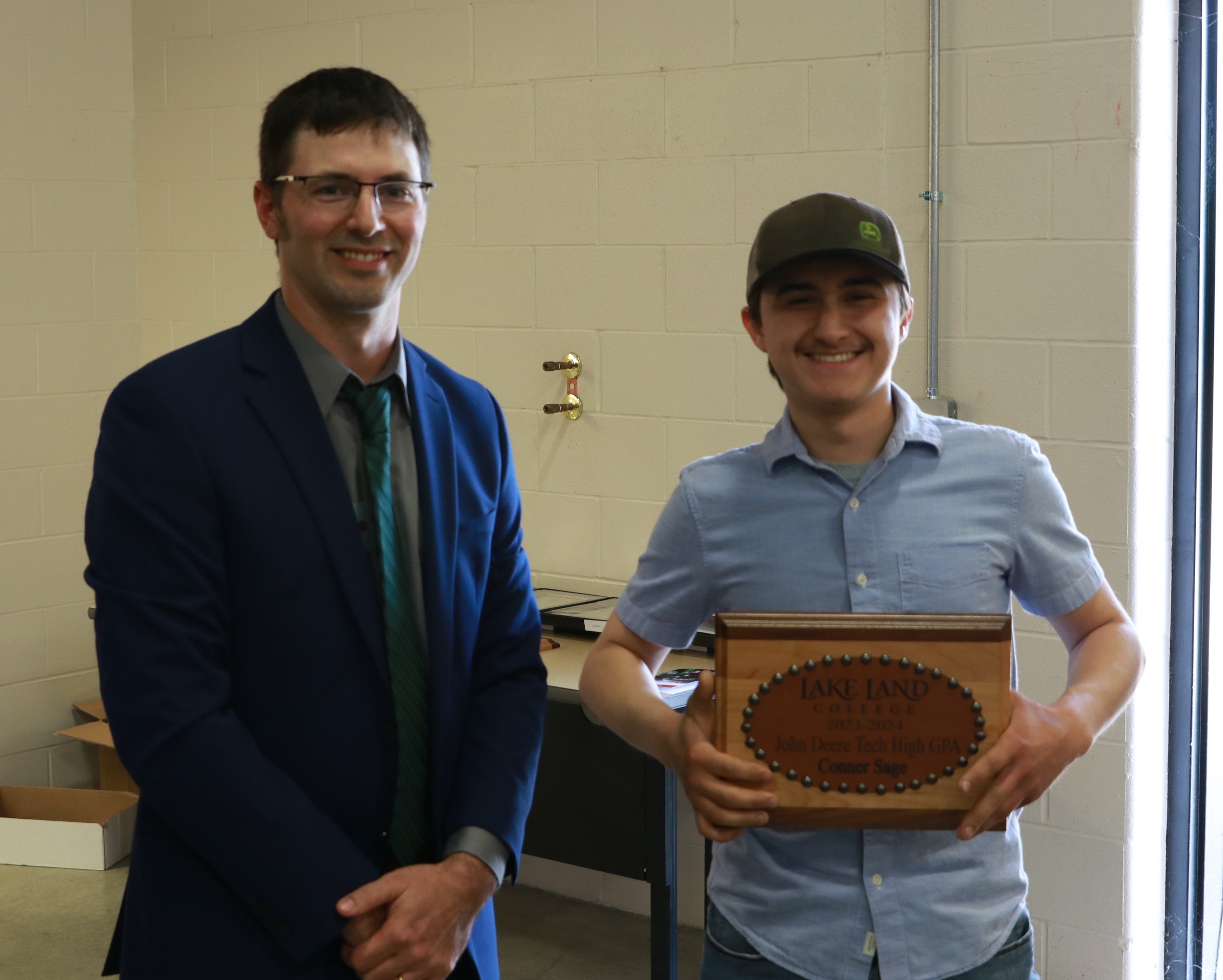 A John Deere Instructor presenting an award to a graduating student