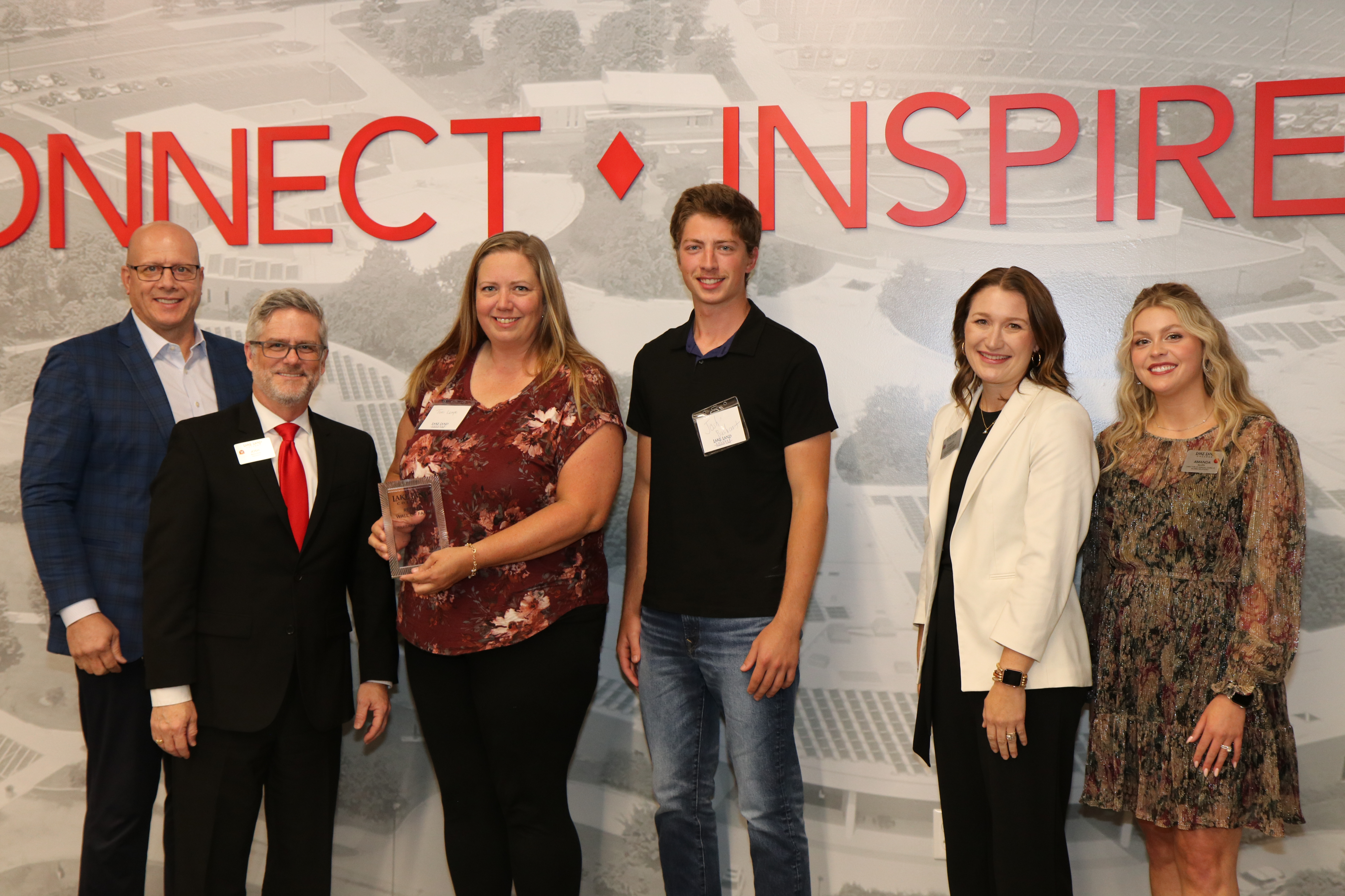 The daughter and grandson of a Lake Land College Retiree Wall of Fame inductee accept the award at a ceremony. 