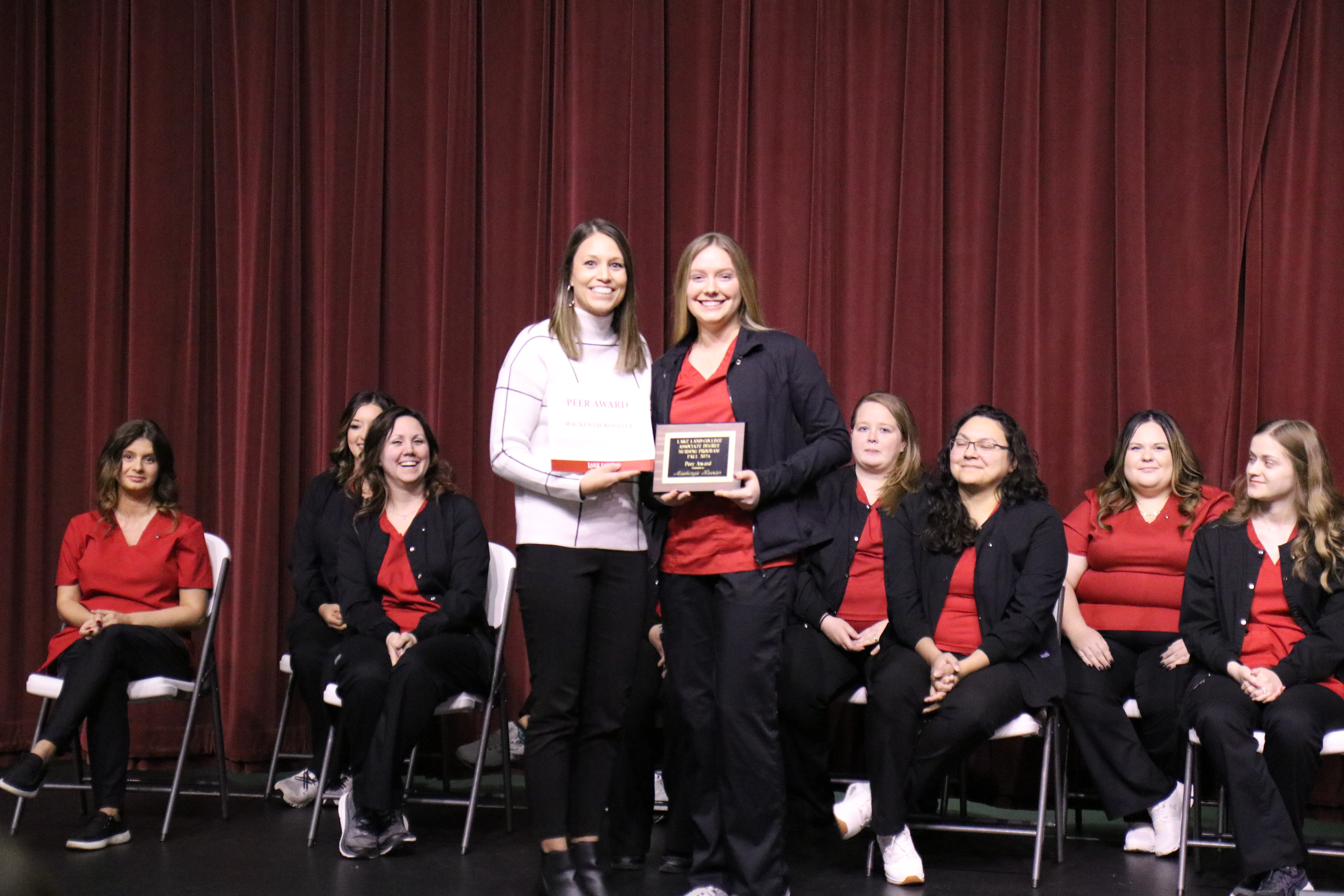 A nursing instructor presenting an award to a graduating student during a pinning ceremony