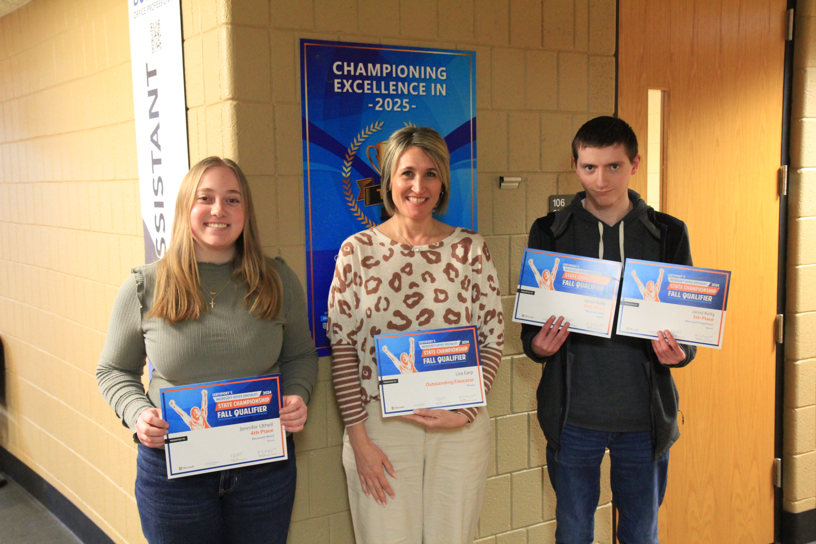 Two Lake Land College students and an instructor holding awards they received from the Microsoft Office Specialist State Championship.